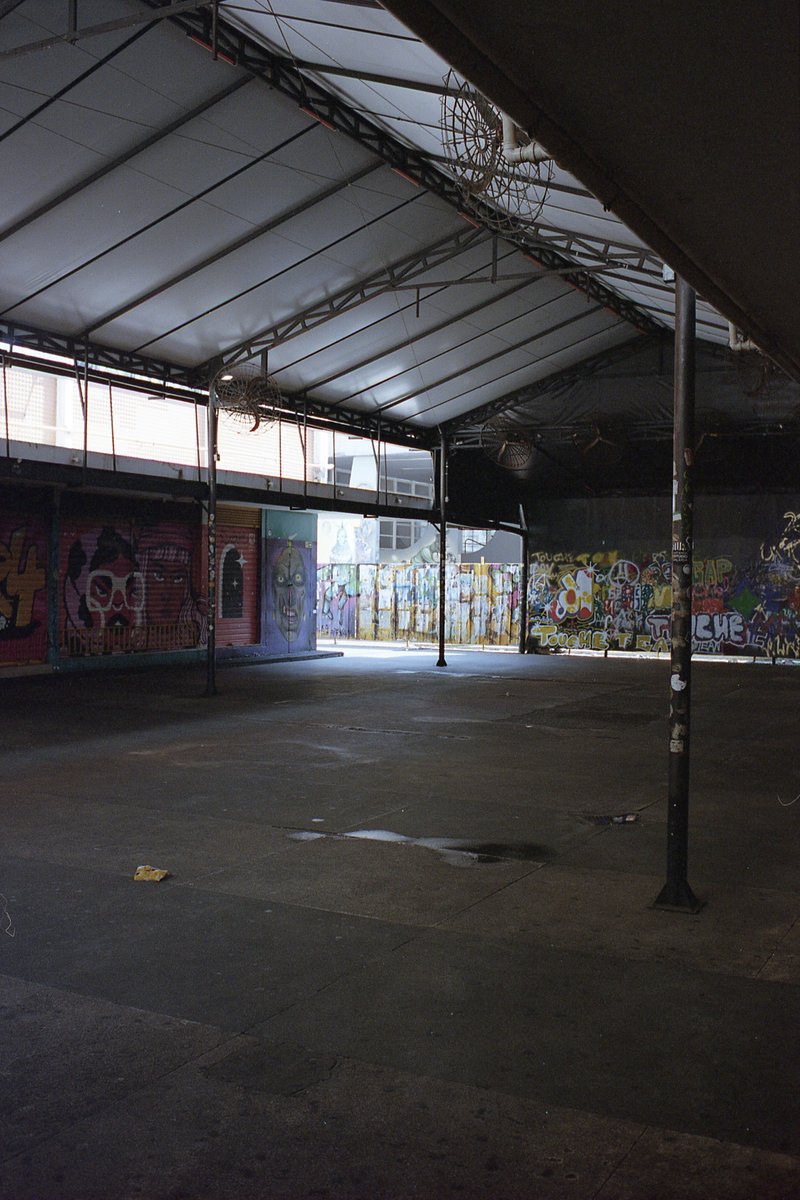 The image captures an indoor scene featuring a spacious room with high ceilings. The room has a concrete floor and appears to be empty at the moment.