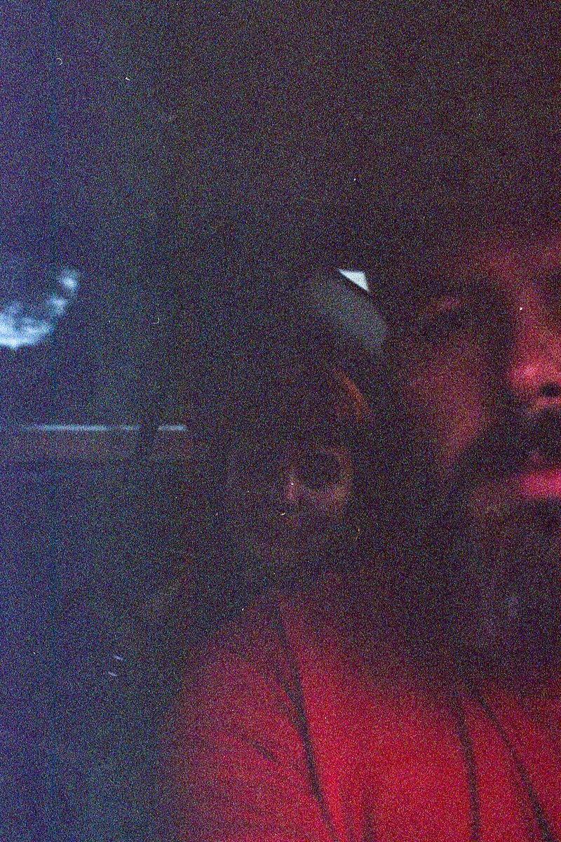 The image is a photograph with a dark, almost black background. At the top of the image, there's a bright red light. Below the red light, taking up th