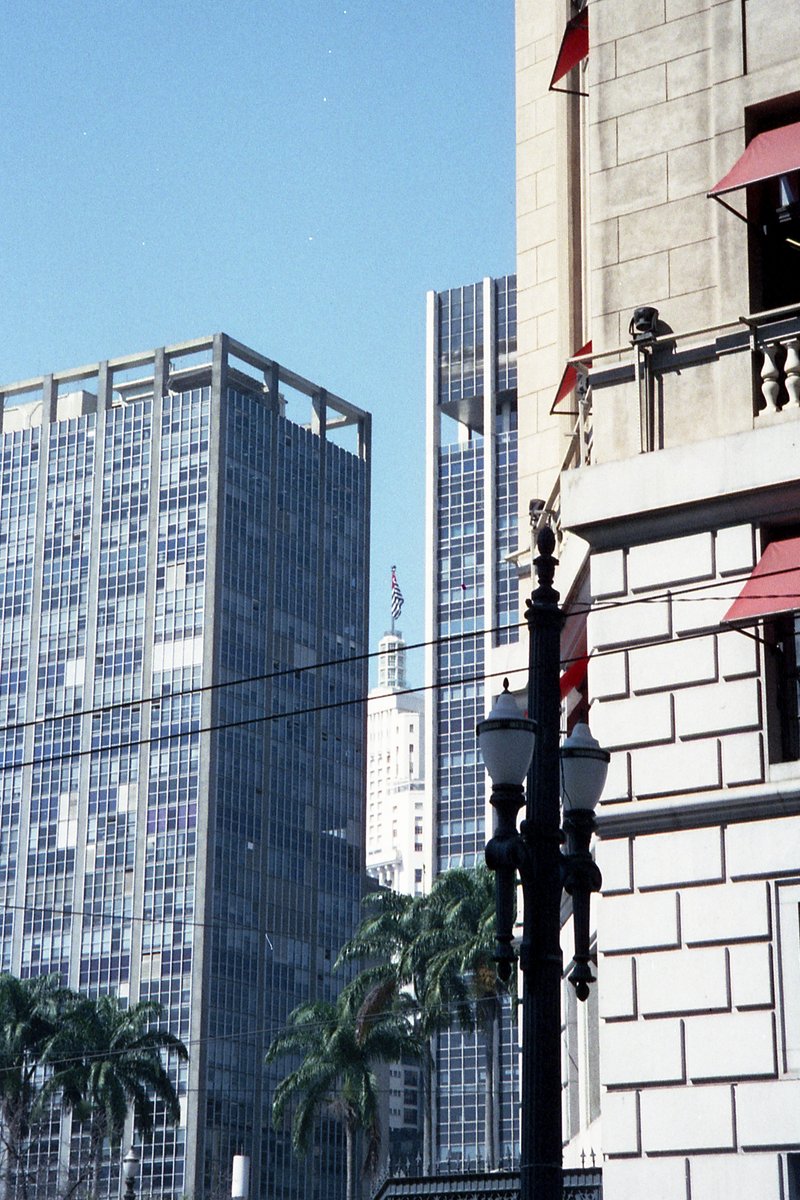 This is a cityscape image featuring a mix of high-rise buildings and a building under construction. The perspective appears to be from street level, l