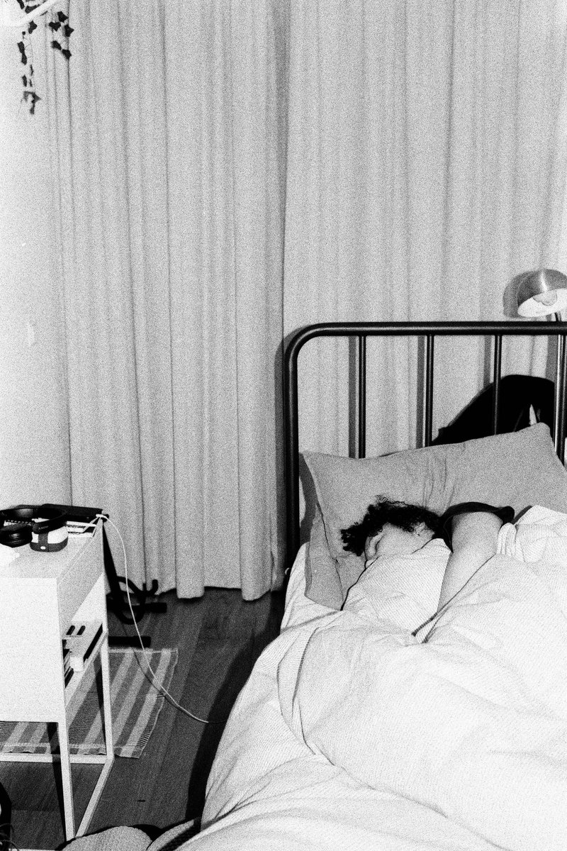 The image is in black and white, showing a patient in bed, surrounded by medical equipment. There's no text or additional objects visible.